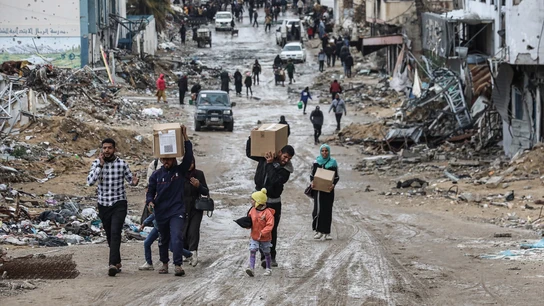 Gazatíes cargan con ayuda humanitaria Gazatíes cargan con ayuda humanitaria