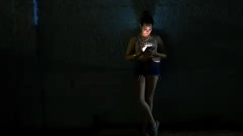 Mujer mirando el móvil a oscuras Mujer mirando el móvil a oscuras