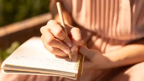 Una mujer escribe en una libreta Una mujer escribe en una libreta