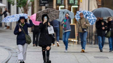 Imágenes de varias personas en la calle bajo la lluvia. 