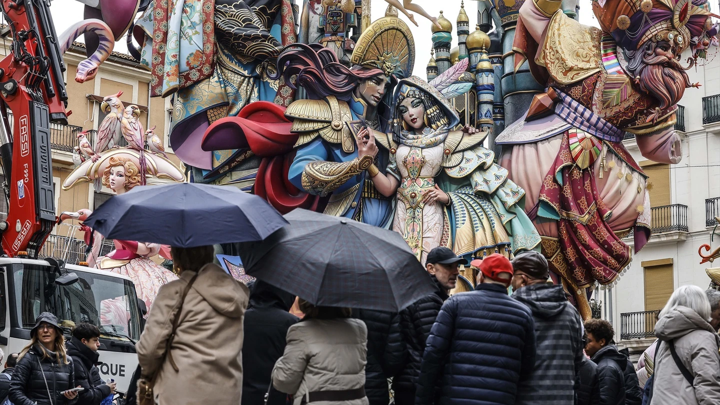 Varias personas con paraguas observan la falla Convento Jerusalén en Valencia. Varias personas con paraguas observan la falla Convento Jerusalén durante su montaje en Valencia a 14 de marzo de 2025.