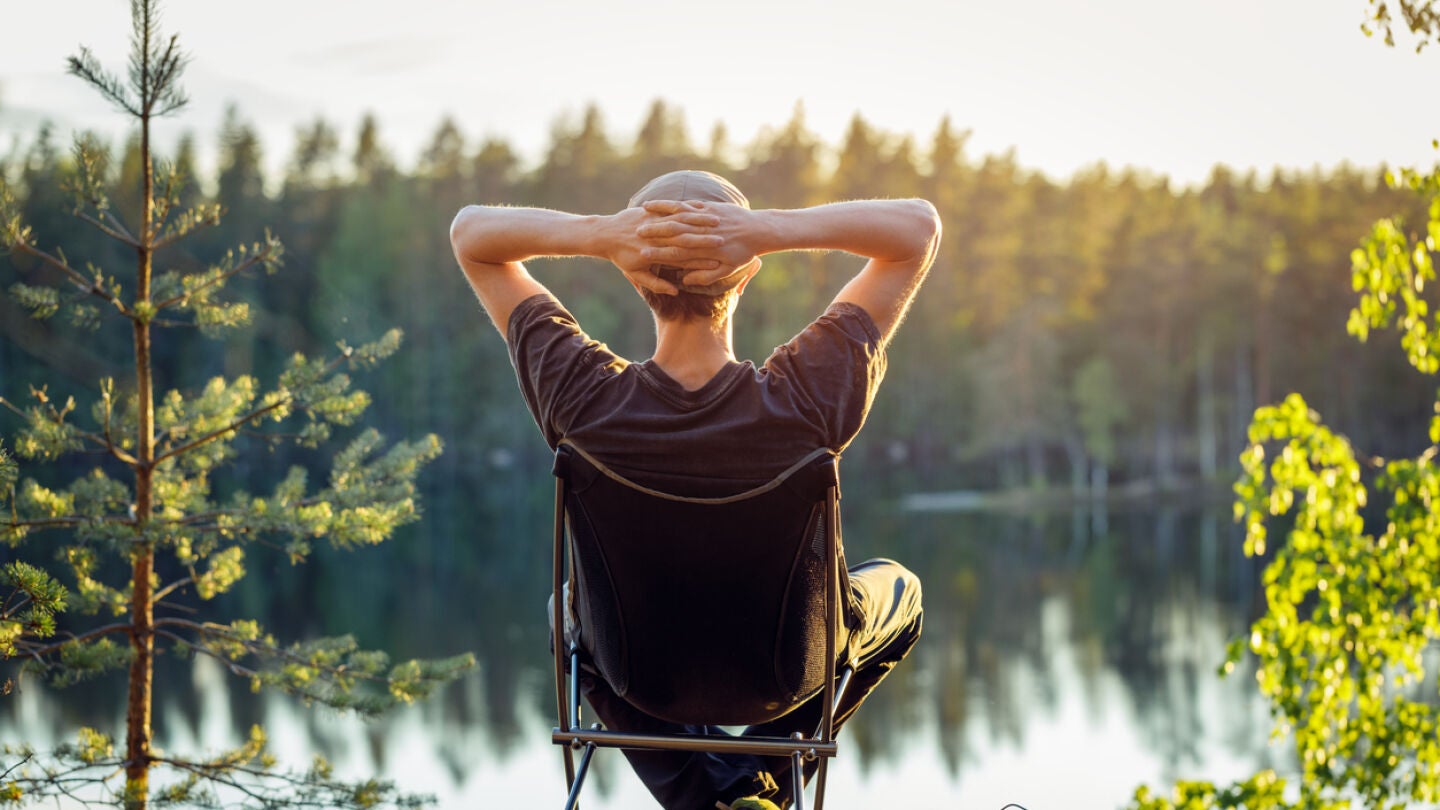 Un hombre disfrutando del atardecer frente al lago