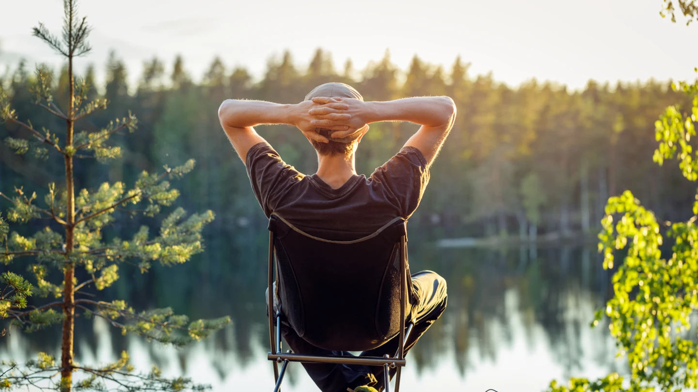 Un hombre disfrutando del atardecer frente al lago Un hombre disfrutando del atardecer frente al lago
