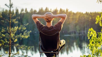 Un hombre disfrutando del atardecer frente al lago