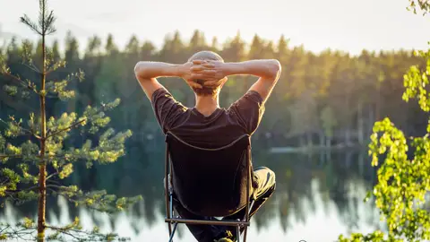 Un hombre disfrutando del atardecer frente al lago Un hombre disfrutando del atardecer frente al lago