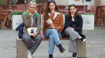 Mujeres sentadas en un banco comiendo