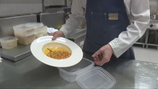 Un cocinero guarda en un tupper comida Un cocinero guarda en un tupper comida