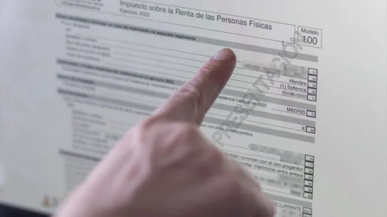Una persona revisando el borrador de su declaración de la renta Una persona revisando el borrador de su declaración de la renta