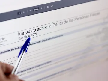 Una persona cumplimenta la declaración de la Renta Una persona cumplimenta la declaración de la Renta