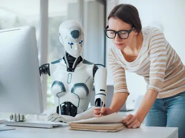 Una mujer y un robot trabajando juntos Una mujer y un robot trabajando juntos