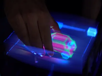 Una mano cogiendo un holograma de un coche. Una mano cogiendo un holograma de un coche.