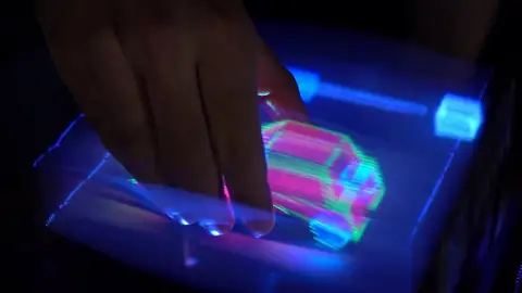 Una mano cogiendo un holograma de un coche. Una mano cogiendo un holograma de un coche.