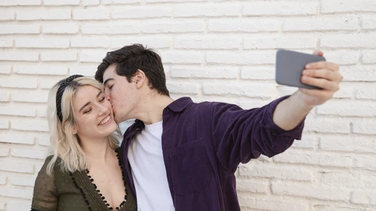 Una pareja joven haciéndose un selfi. Una pareja joven haciéndose un selfi.