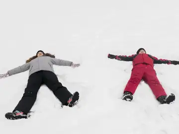Dos niños haciendo ángeles de nieve Dos niños haciendo ángeles de nieve