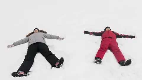 Dos niños haciendo ángeles de nieve Dos niños haciendo ángeles de nieve
