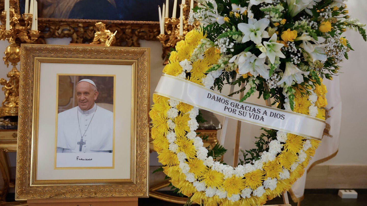 Un retrato del papa Francisco y una corona de flores con los colores del Vaticano presiden la Nunciatura Apost&oacute;lica en Madrid, donde se ha colocado un libro de condolencias. 