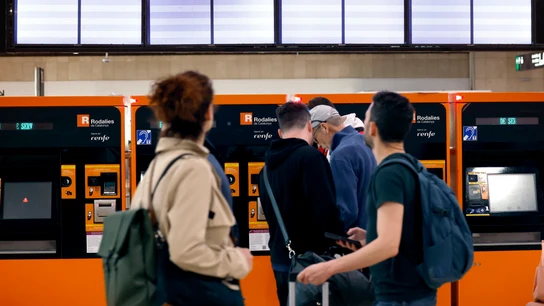 Varias personas consultando el estado de Rodalies en la estación de Sants, en Barcelona Varias personas consultando el estado de Rodalies en la estación de Sants, en Barcelona