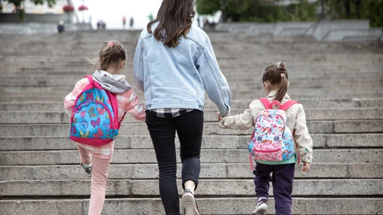 Madre y niñas con mochilas. Madre y niñas con mochilas.