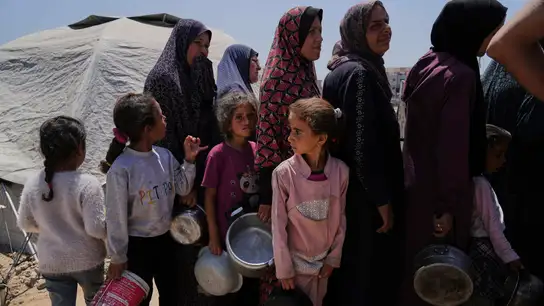 Mujeres y niñas esperan a recibir donaciones en Gaza. Mujeres y niñas esperan a recibir donaciones en Gaza.