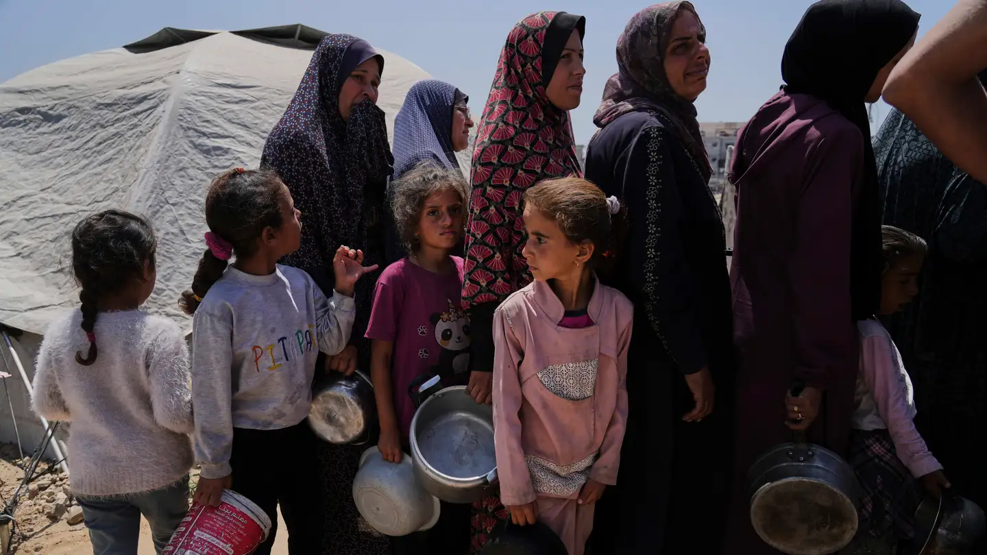 Mujeres y niñas esperan a recibir donaciones en Gaza. Mujeres y niñas esperan a recibir donaciones en Gaza.