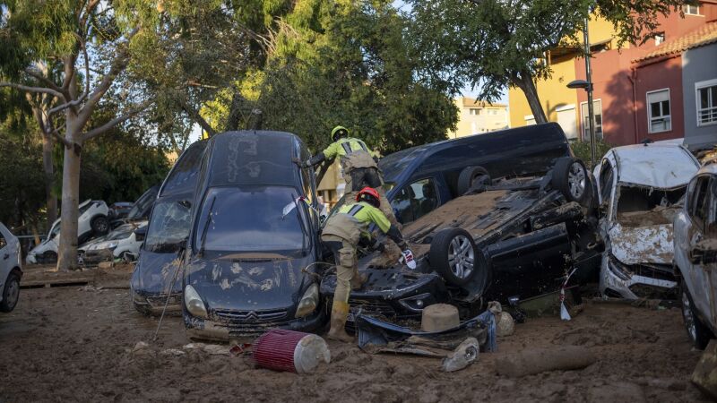 Varios bomberos buscan a personas entre coches, a 2 de noviembre de 2024, en Alfafar, Valencia.