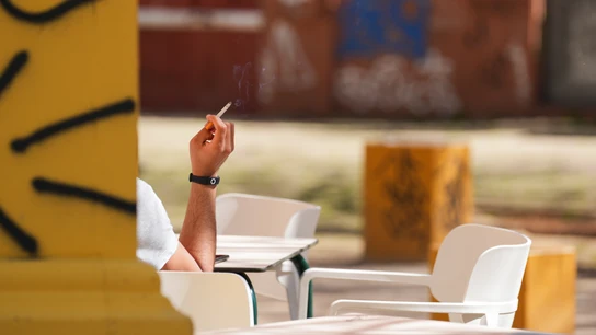 Una persona fumando en una terraza, en una imagen de archivo Una persona fumando en una terraza, en una imagen de archivo