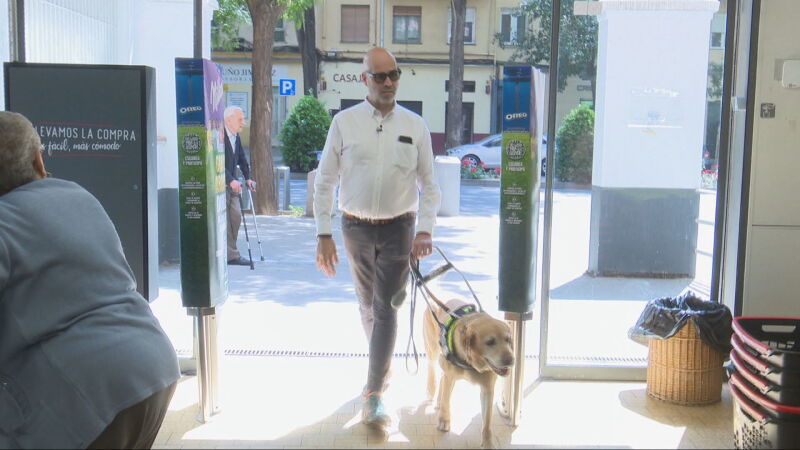Jonathan Armengol entrando en un establecimiento con su perro guía