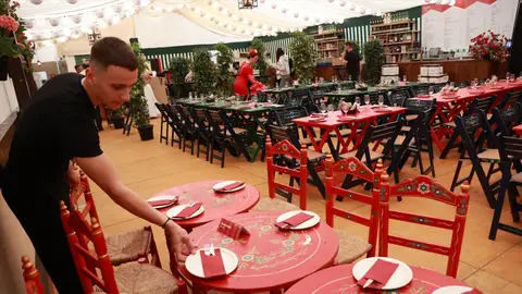 Un camarero prepara las mesas del interior de una caseta de la Feria de Sevilla. Un camarero prepara las mesas del interior de una caseta de la Feria de Sevilla.