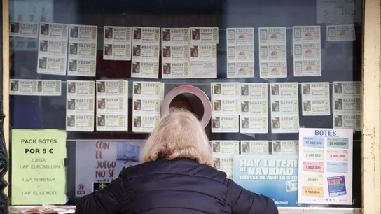 Una mujer adquiere su décimo para la Lotería Nacional en una istración de Loterías. Una mujer adquiere su décimo para la Lotería Nacional en el mostrador de istración de Loterías.