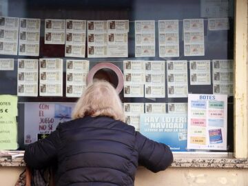 Una mujer adquiere su décimo para la Lotería Nacional en una Administración de Loterías.