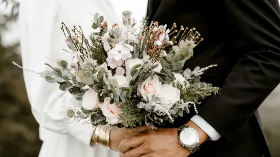 Una pareja sostiene un ramo de flores durante su boda Una pareja sostiene un ramo de flores durante su boda