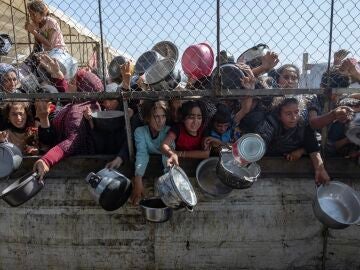 Palestinos desplazados se agolpan frente a un comedor social.