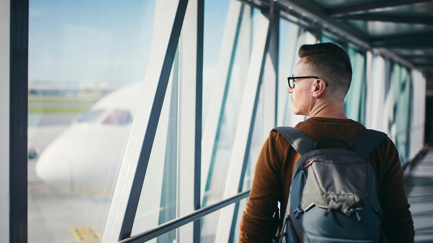 Pasajero subiendo al avión con mochila Pasajero subiendo al avión con mochila