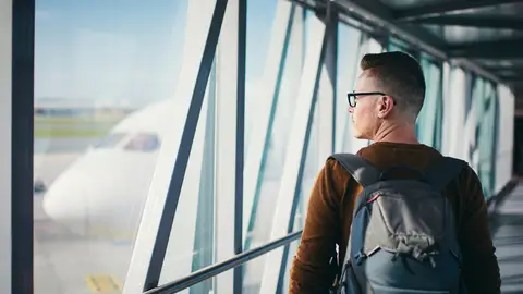 Pasajero subiendo al avión con mochila Pasajero subiendo al avión con mochila