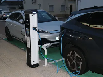 Dos vehículos recargando batería en una estación de red eléctrica Dos vehículos recargando batería en una estación de red eléctrica