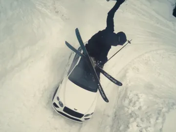 Esquiador saltando por encima del Bentayga Speed en mitad de la nieve Esquiador saltando por encima del Bentayga Speed en mitad de la nieve