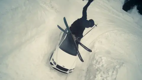 Esquiador saltando por encima del Bentayga Speed en mitad de la nieve Esquiador saltando por encima del Bentayga Speed en mitad de la nieve