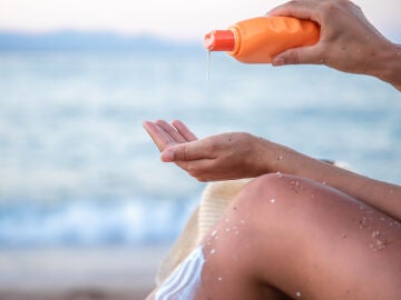 Mujer en la playa con crema solar