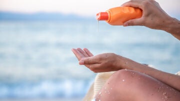 Mujer en la playa con crema solar