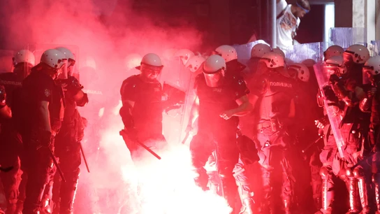 Agentes de la Policía de Serbia apagan una bengala durante las protestas en Belgrado Agentes de la Policía de Serbia apagan una bengala durante las protestas en Belgrado