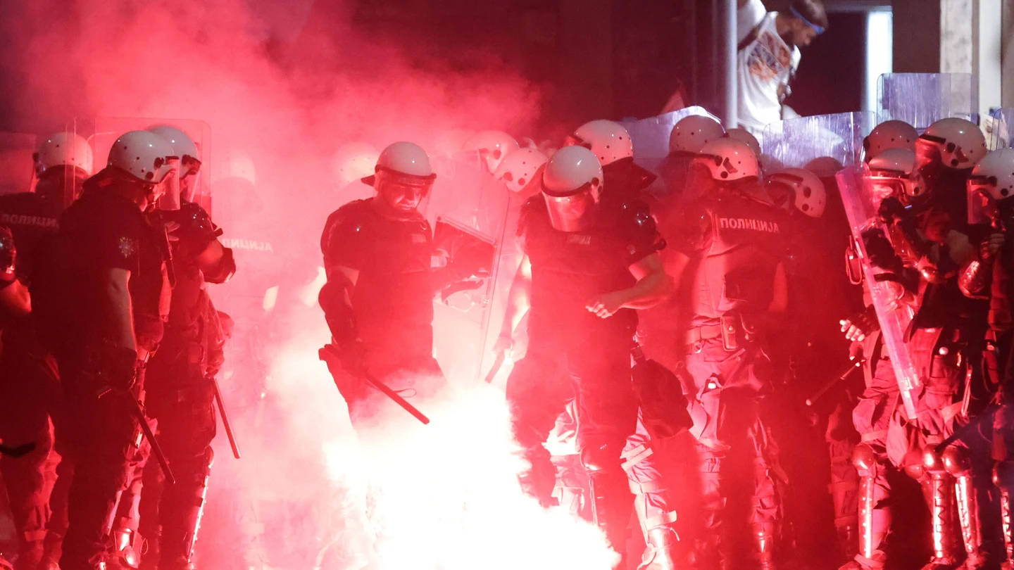 Agentes de la Policía de Serbia apagan una bengala durante las protestas en Belgrado Agentes de la Policía de Serbia apagan una bengala durante las protestas en Belgrado