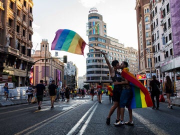 Una pareja, besándose en la Gran Vía de Madrid, cortada para las fiestas del Orgullo en 2018