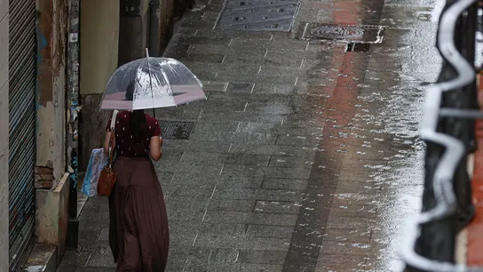 Una mujer camina bajo la lluvia en Valencia. Una mujer camina bajo la lluvia en Valencia.