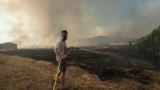 Un residente intenta extinguir el incendio con agua. Un residente intenta extinguir el incendio con agua.