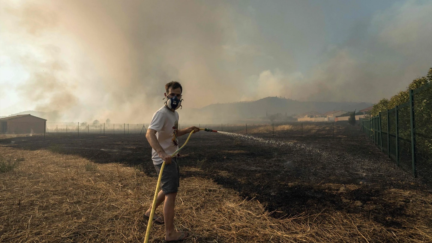 Un residente intenta extinguir el incendio con agua. Un residente intenta extinguir el incendio con agua.
