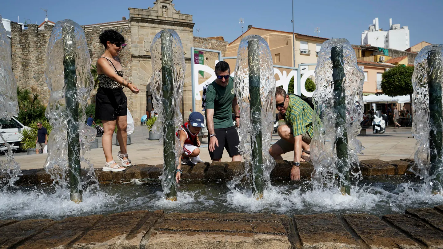 Una familia se refresca en una fuente en Plasencia, este martes Una familia se refresca en una fuente en Plasencia, este martes