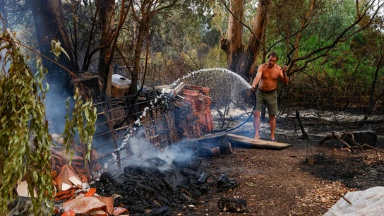 Una persona intenta apagar unas llamas en el incendio del paraje La Peña. Una persona intenta apagar unas llamas en el incendio del paraje La Peña.