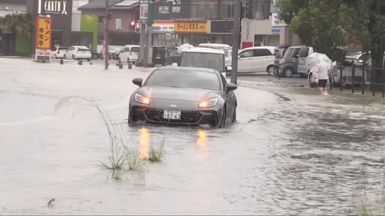 Un coche, en una calle inundada en Japón Un coche, en una calle inundada en Japón