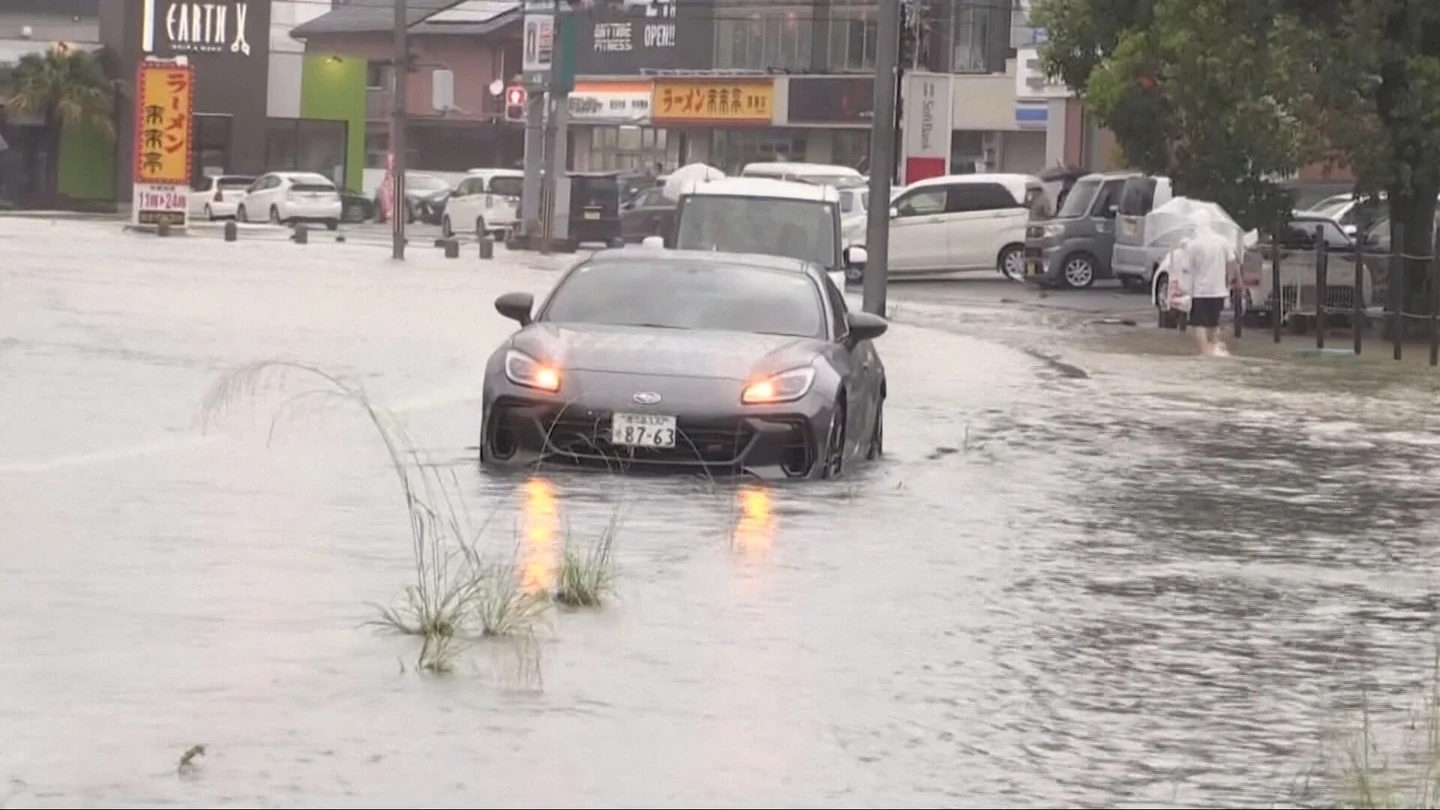 Un coche, en una calle inundada en Japón Un coche, en una calle inundada en Japón