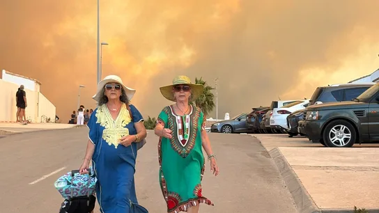 Dos mujeres durante el desalojo preventivo de viviendas, hoteles y la playa de los Alemanes por el fuego en Tarfia este lunes. Dos mujeres durante el desalojo preventivo de viviendas, hoteles y la playa de los Alemanes por el fuego en Tarfia este lunes.